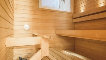 Una sauna con bancos de madera y un ventanal.