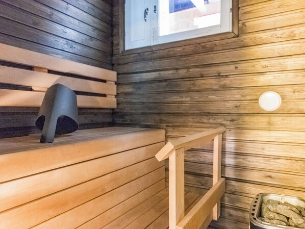 A sauna with wooden benches and a small window.