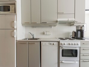 A kitchen with a microwave, dishwasher, stove, oven, and coffee maker.