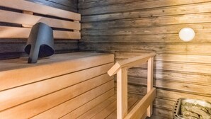 A sauna room with wooden benches and a bench with a backrest.