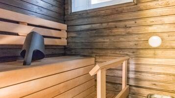 A sauna room with wooden benches and a bench with a backrest.