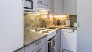 A compact kitchenette with a microwave, stove, sink, and Bosch dishwasher. - Saariseläntie 8 a 8 by Interhome (Inari)