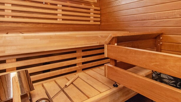 Una sauna de madera con bancos y una ventana.