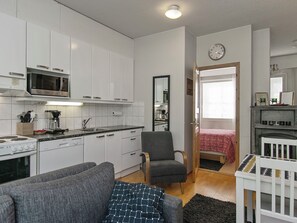 En kompakt bolig med tekøkken, spiseplads og soveværelse.