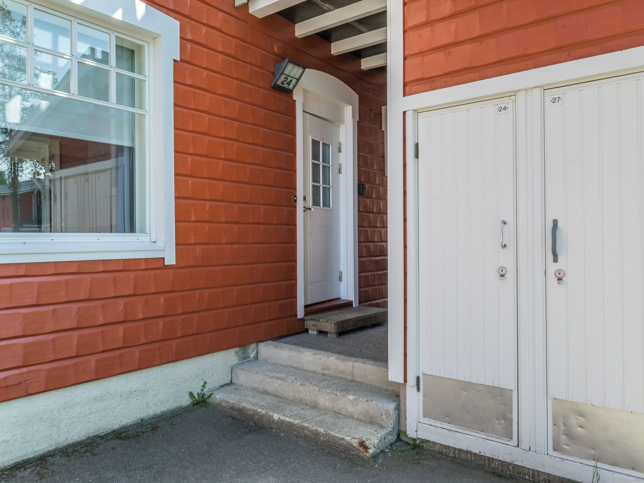 A red house with a white door and a garage door.