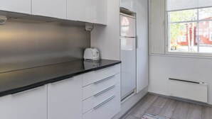 A modern kitchen with white cabinets, a black countertop, and a built-in oven.