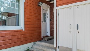 A red house with a white door and a garage door.
