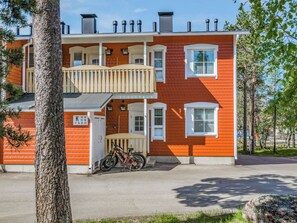 Een tweelaags gebouw met een balkon, een fiets ervoor en een heldere lucht.