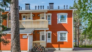 Een gebouw met twee verdiepingen, een rode gevel, witte ramen en een balkon.