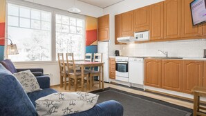 Une cuisine moderne avec des meubles en bois, une cuisinière blanche et un four à micro-ondes encastré.