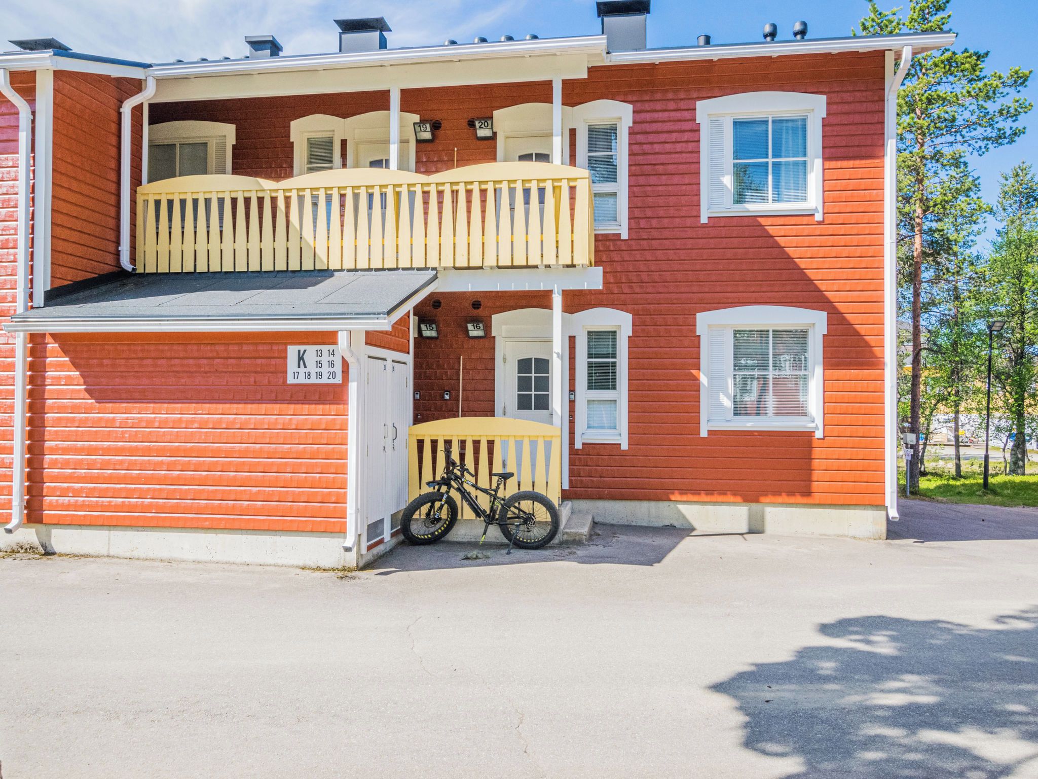 A two-story building with a balcony on the upper floor and a bicycle parked outside.
