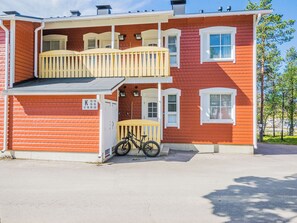 En toetagers bygning med balkon på øverste etage og en cykel parkeret udenfor.