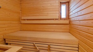 A sauna room with wooden walls and benches.
