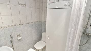 A bathroom with a toilet, sink, and shower.
