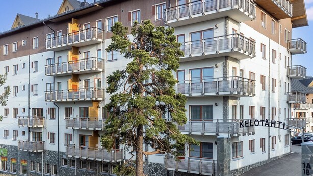 Ein mehrstöckiges Hotel mit Balkonen, einer Steinfassade und einem Schild mit der Aufschrift 'KELOTÄHTI'.