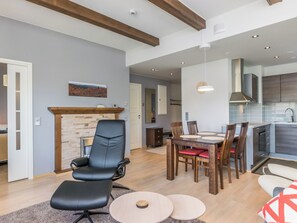 Una sala de estar moderna con chimenea, comedor y cocina.