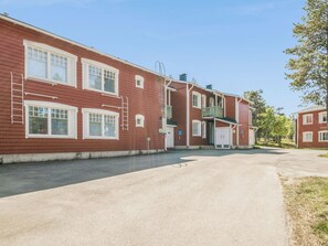 En rødstensbygning i to etager med mange vinduer, en midterliggende dør og en lille balkon.