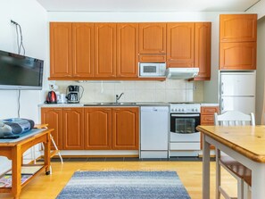 Una cocina funcional con armarios de madera, microondas, estufa y lavavajillas.