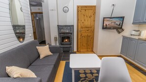 Un salon chaleureux avec une cheminée, un canapé, une table basse et un téléviseur.