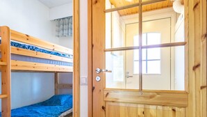 A wooden bunk bed room with a door that has a window.