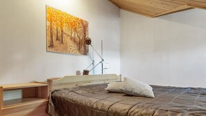 Ein Schlafzimmer mit einem hölzernen Bett, einem Nachttisch, einer Lampe und einem Gemälde an der Wand.