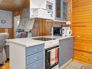 A compact kitchenette with a microwave, coffee maker, and oven.