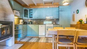 Una cocina con armarios azul claro, una mesa de comedor de madera y sillas.