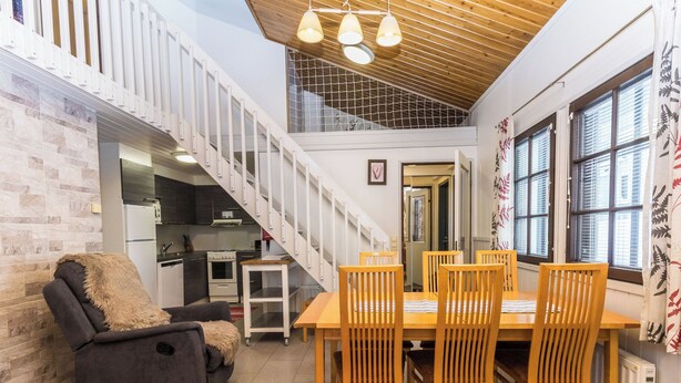 Een modern interieur met een eethoek, keuken en een trap.