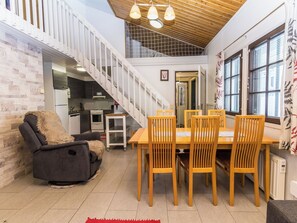 A modern interior with a dining area, kitchen, and staircase.
