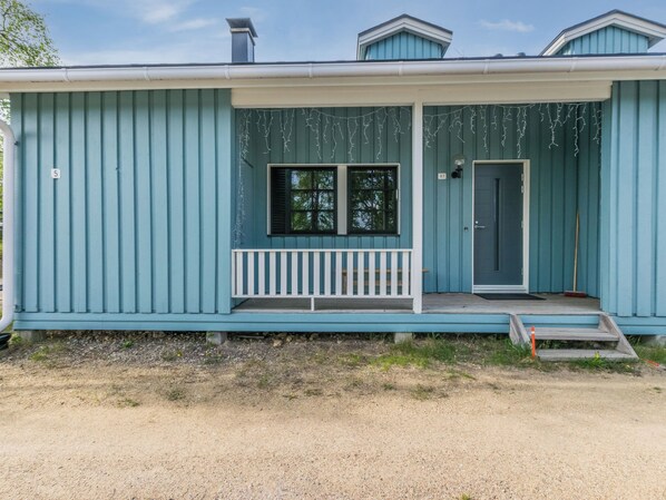 A single-story building with a porch, a door, and a window.
