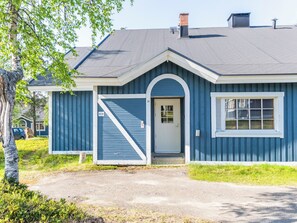 Een gelijkvloers huis met een puntige dakkapel, een voordeur en een klein raam.