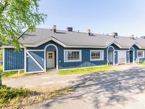 A row of blue buildings with a flat roof, a gated entrance, and a clear sky. - Teerenpesue e 38 by Interhome (Inari)