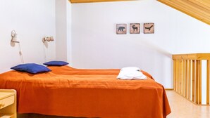 Une chambre avec un lit simple, une table de chevet, un plafond en bois et trois tableaux représentant des animaux, accrochés au mur.