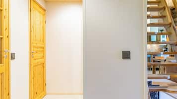 Un couloir avec des portes en bois et un escalier menant à l’étage supérieur.