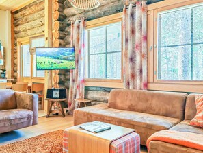 Una sala de estar acogedora con televisor, sofá y una mesa de centro.