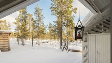 Ett snöigt landskap med en trästuga och en vit byggnad med en dörr.