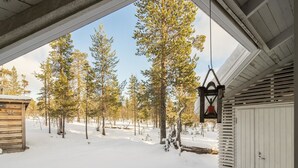 Un paysage enneigé avec une cabane en bois et une lanterne suspendue.