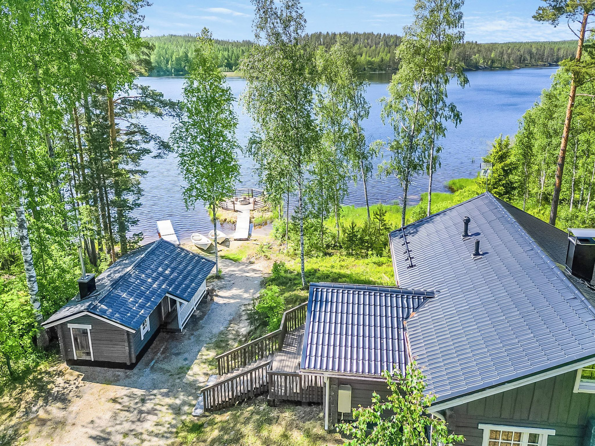 Un chalet au bord du lac, doté d’une terrasse, d’un petit quai et d’un bateau.