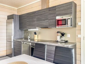 Una cocina moderna equipada con microondas, cafetera y lavavajillas.