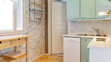 Een koelkast, een magnetron, een vaatwasser, kookgerei, borden en bestek