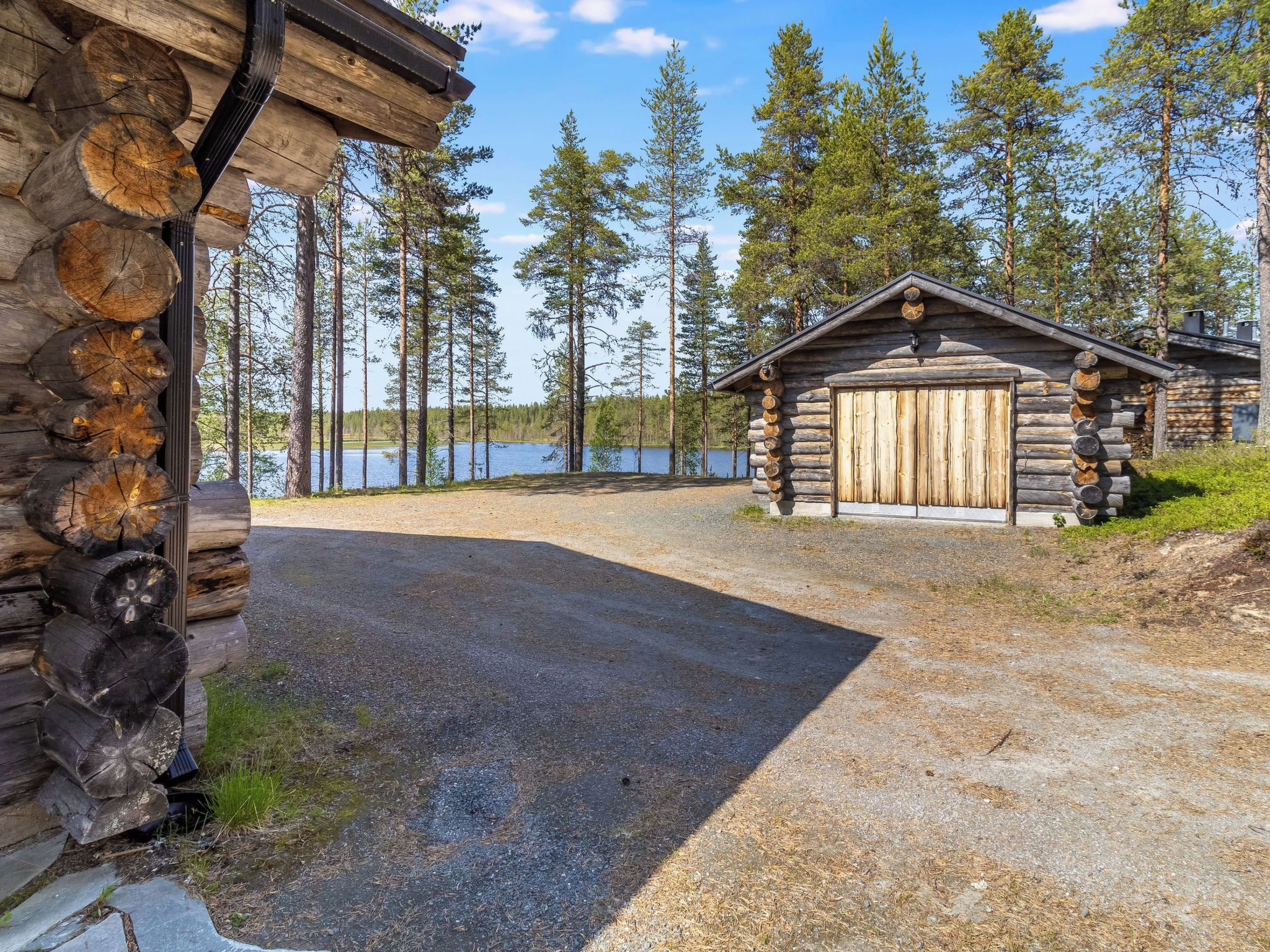 Tunnelmallinen, maalaishenkinen mökki, jonka edessä on sorapäällysteinen ajotie, joka johtaa puiselle ovelle. Mökkiä ympäröivät korkeat mänty- ja kuusipuut sekä järvi.
