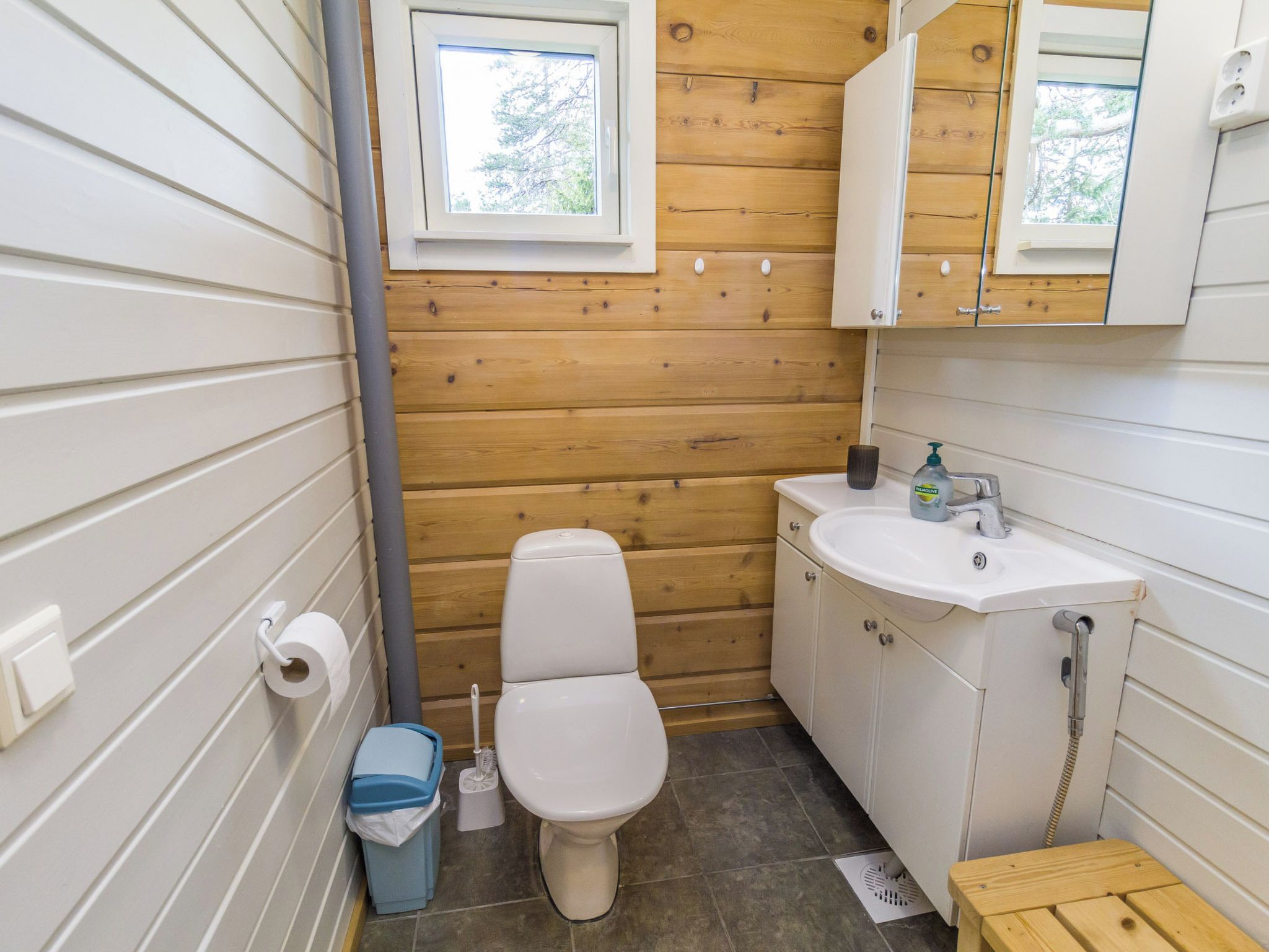 Une petite salle de bain comprenant des toilettes, un lavabo et un miroir.