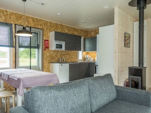 A compact living space with a kitchenette, a sofa, a dining table, and a fireplace. - Kaisala by Interhome (Hailuoto)