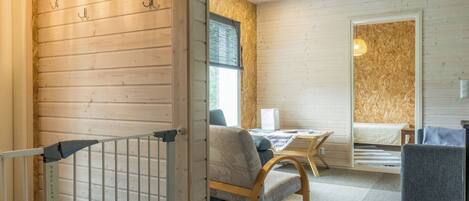 Un interior moderno con una pared de madera, una cama, un escritorio y una silla.