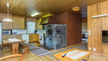 Une cuisine compacte avec des meubles en bois, un four encastré et un mur en briques.