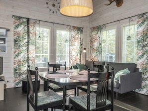A dining area with a round table, chairs, and a sofa. - Kuurankuksa a by Interhome (Kittilä)