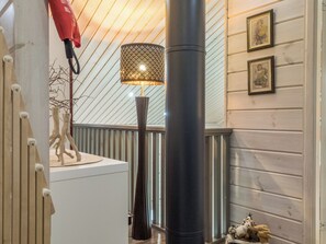 Un pasillo decorado con una lámpara, una escultura y cuadros en la pared.