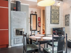 A modern kitchen with a dining area, featuring a marble backsplash, a built-in oven, and a large mirror above the counter.