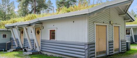 A log cabin with a sloped roof, a front door, and a small porch area.