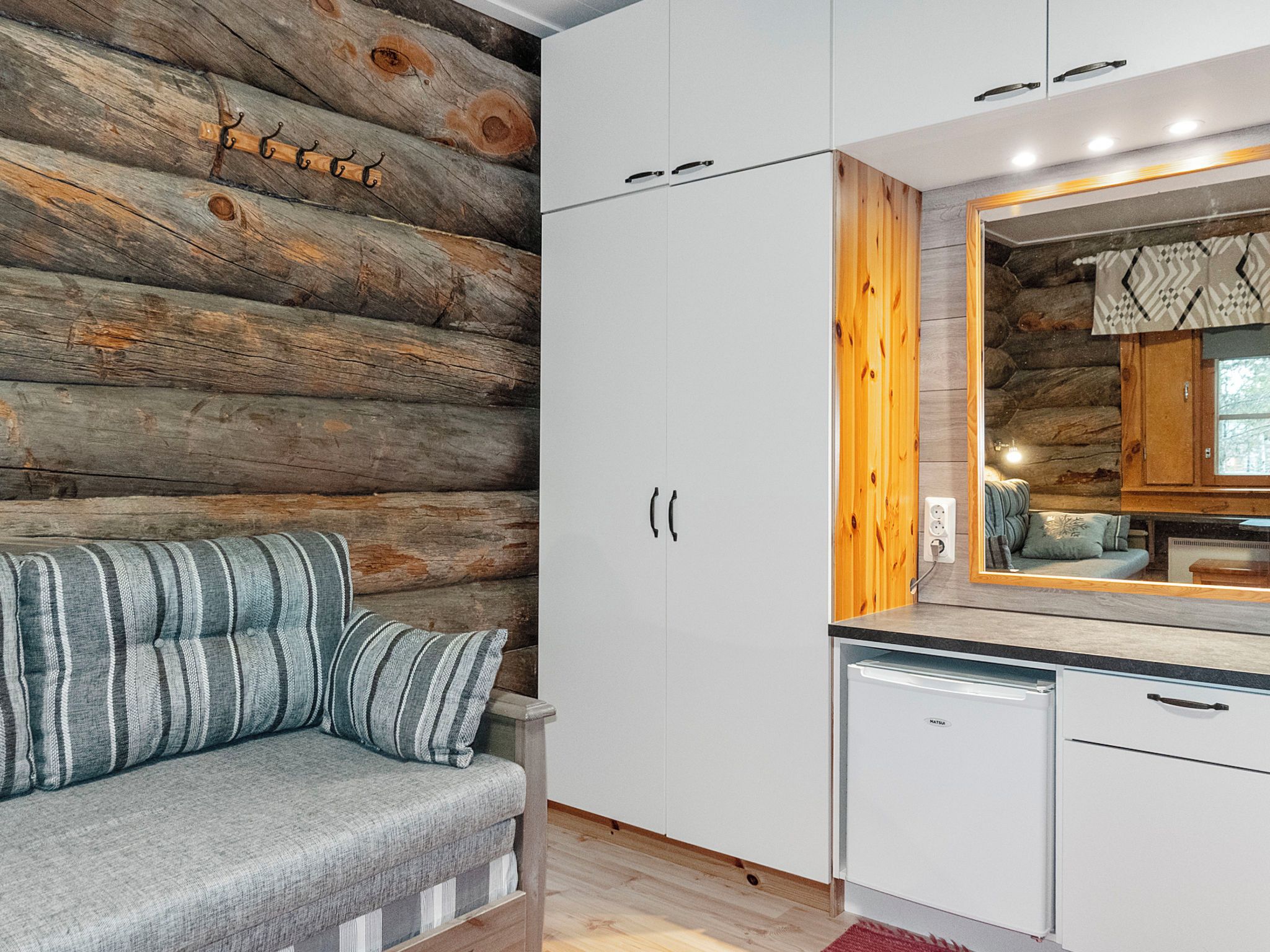 Een moderne keuken met witte kasten, een ingebouwde oven en een houten wand.